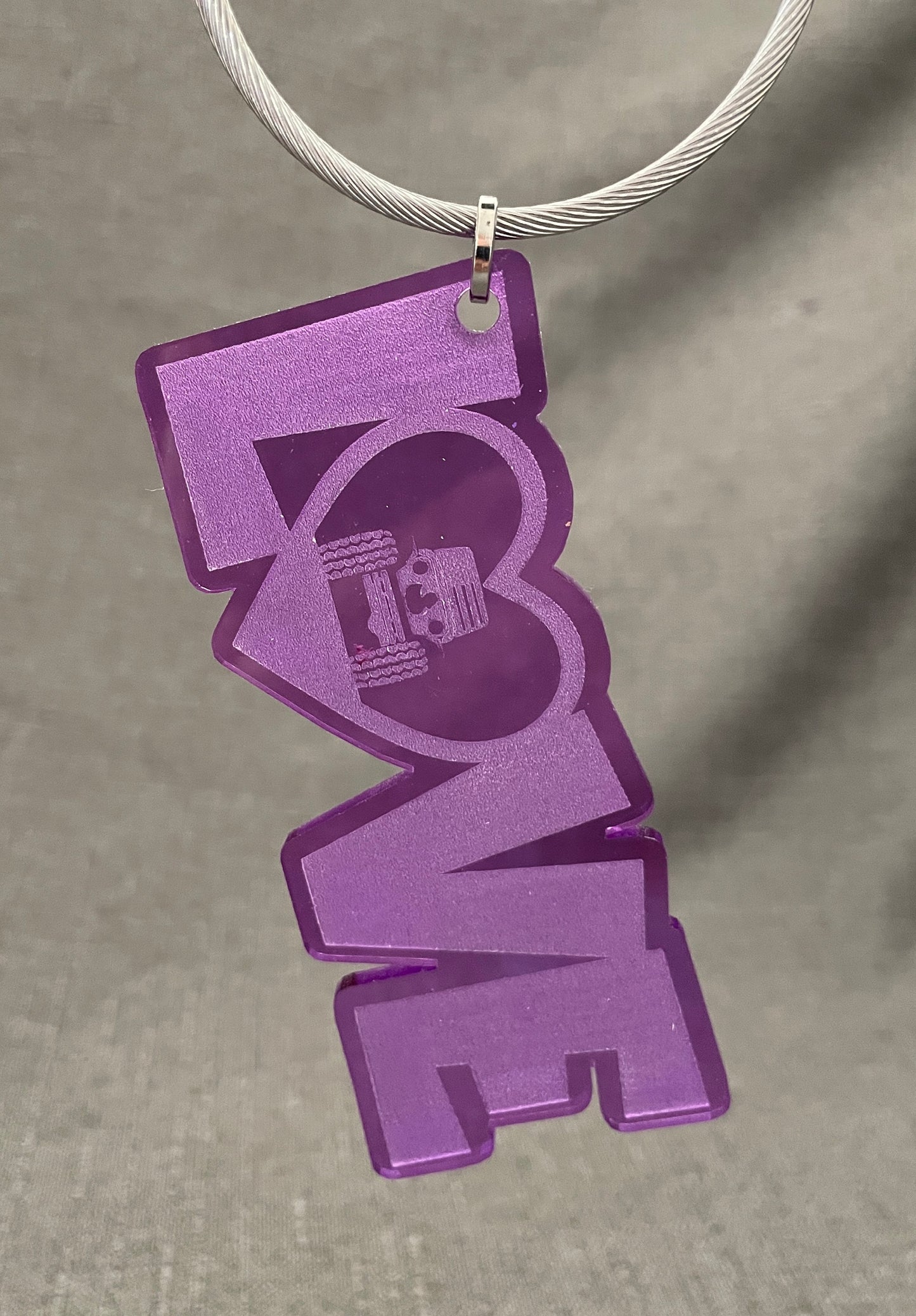 LOVE car charm in purple with the O shaped like a heart featuring a Jeep inside, with tires touching the heart sides.