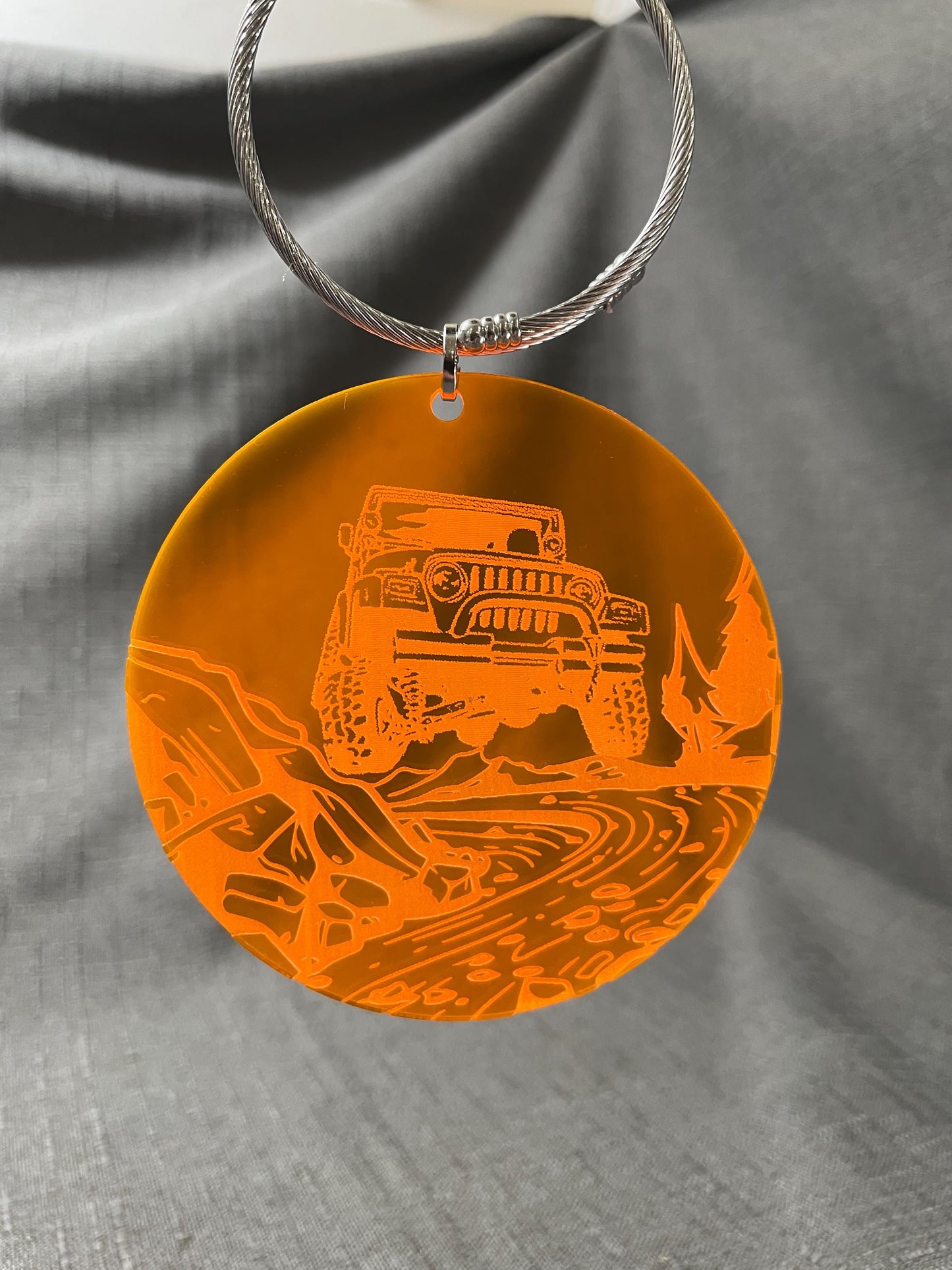 Jeep-themed Adventure car charm hanging on an orange background, engraved river bed design for 4x4 fans.