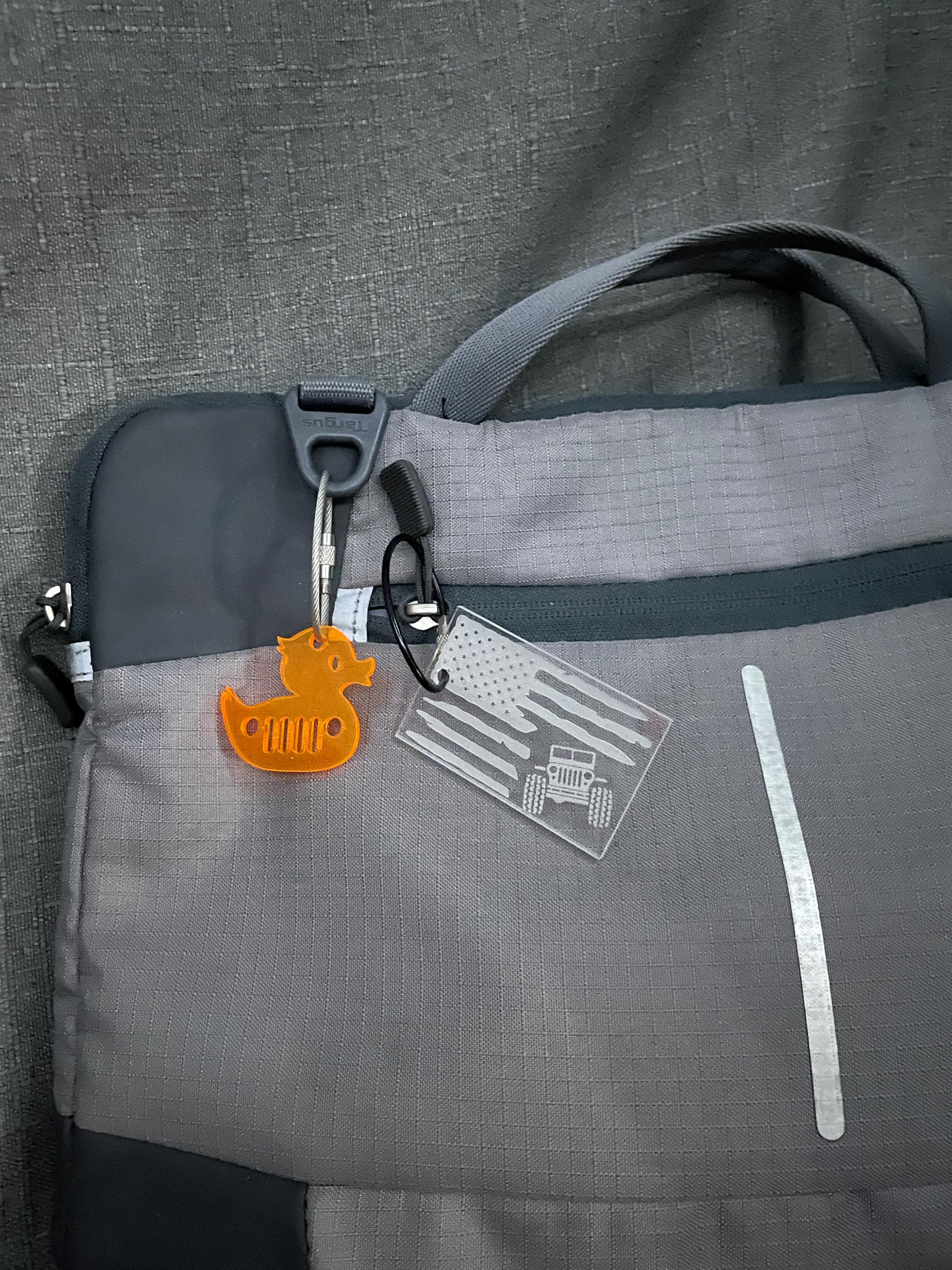 Orange mini duck key chain with Jeep grill cut-out on a laptop bag, adding a pop of color and Jeep flair to accessories.